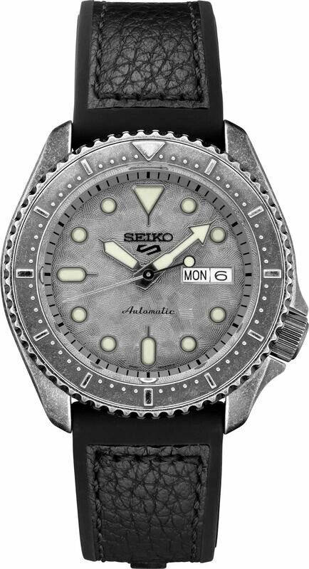 Close-up of a Seiko wristwatch with a textured dial and day-date display.