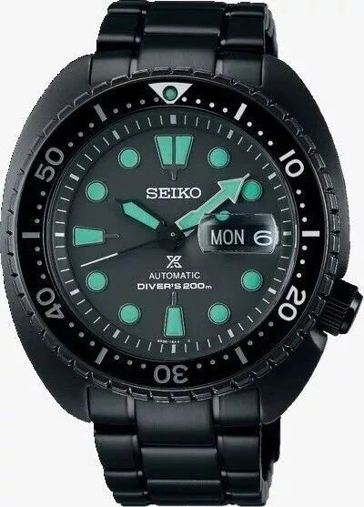 Black Seiko dive watch with luminous hands and markers.