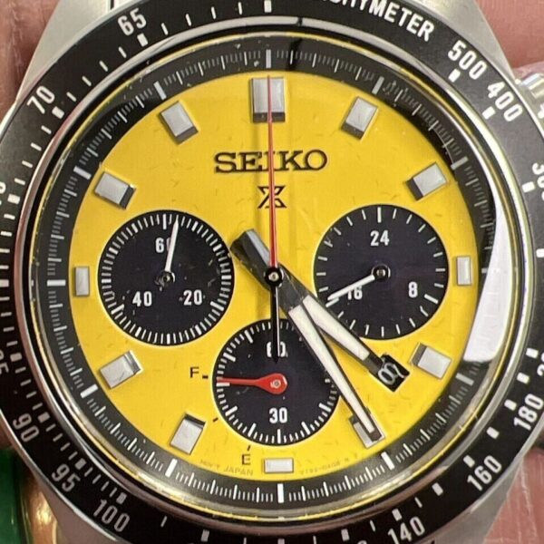 Close-up of a yellow Seiko chronograph watch face with black subdials.