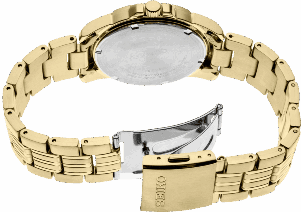 A close-up of a gold wristwatch with an open clasp.