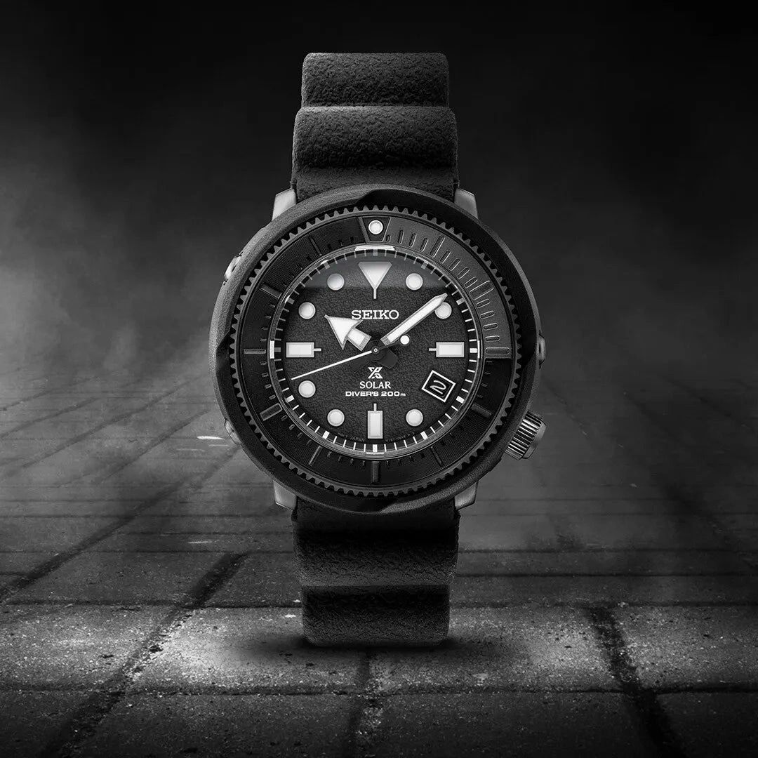 Black wristwatch with a bold design on a textured surface.